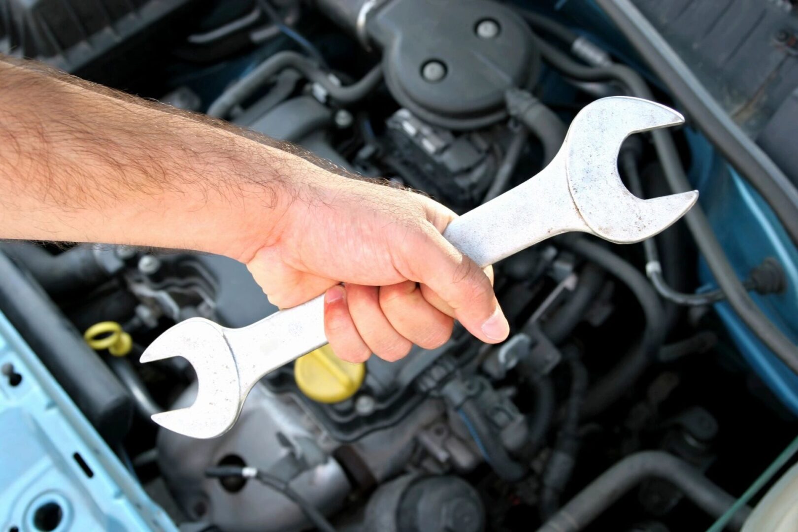 A person holding two wrenches in their hand.